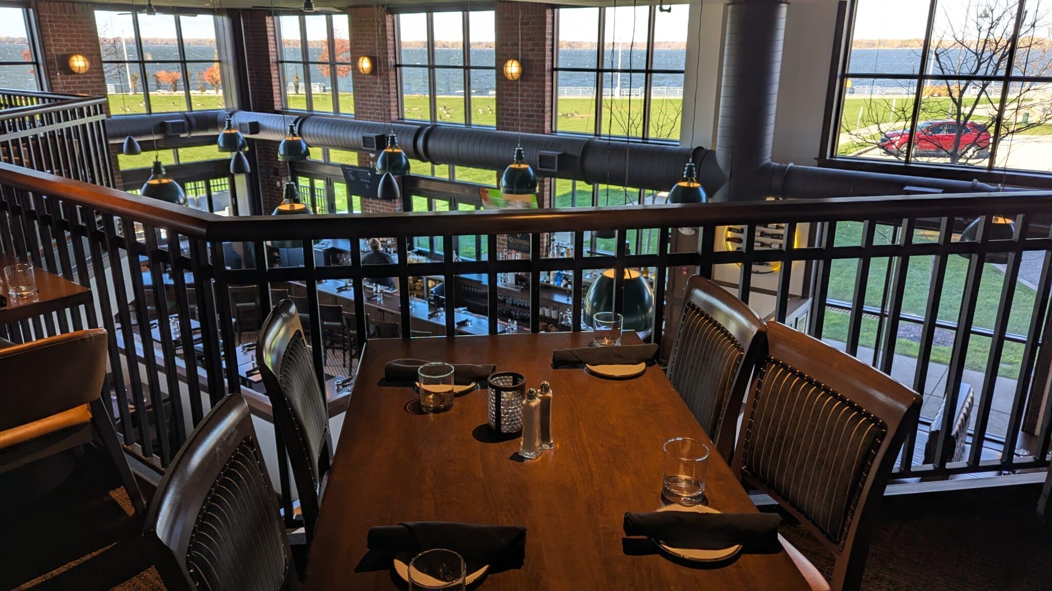 A table in Bayhouse Oyster Bar overlooking a bar area and Presque Isle Bay outside the windows