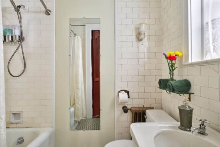 bathroom with white tile, antique sink, toilet tub/shower combination
