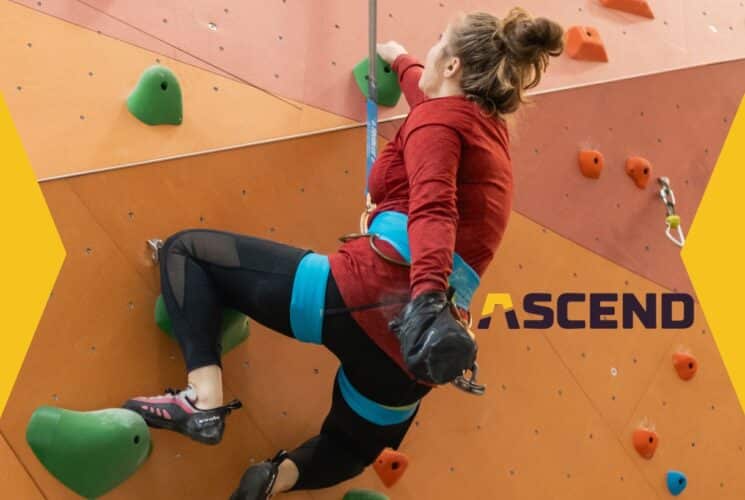 A girl climbing an inside rock wall