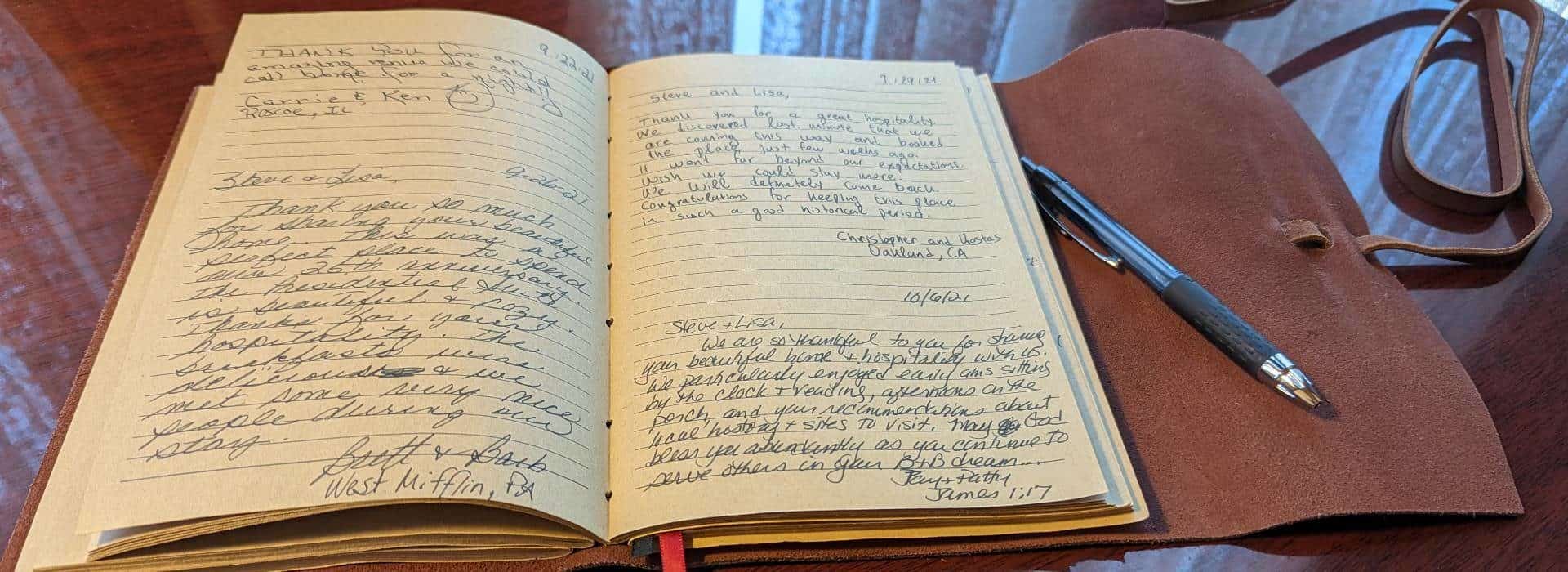 Leather bound journal with guest comments laying open on a wooden table