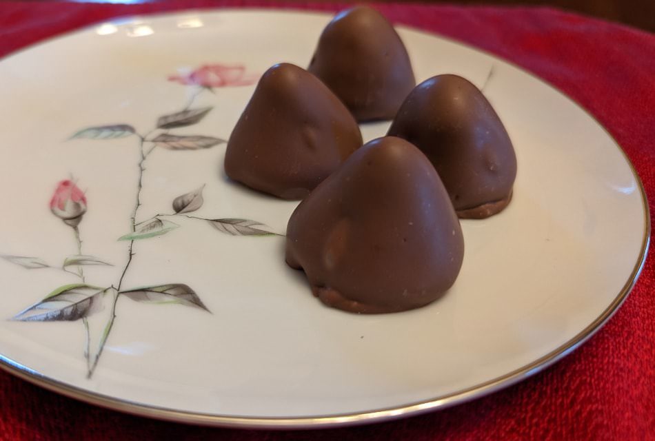 Close up view of chocolate covered strawberries on a white porcelain plate