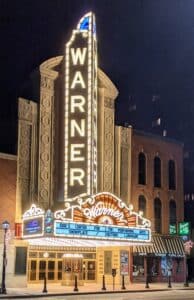 The historic Warner Theatre marquee illuminated at night in downtown Erie, Pennsylvania.